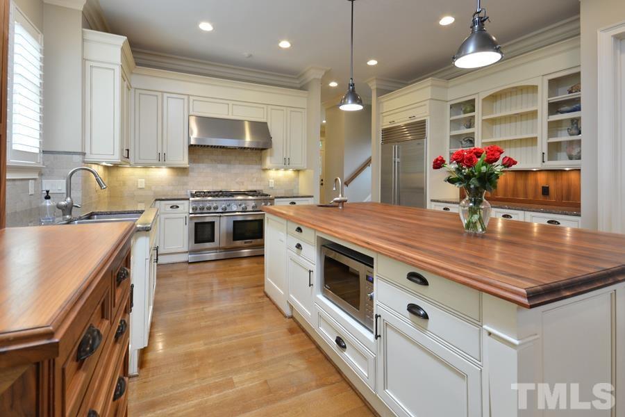 7 Springhouse Place Durham, NC 27705 - Photo 9 of 30 a kitchen with stainless steel appliances granite countertop a sink stove and cabinets
