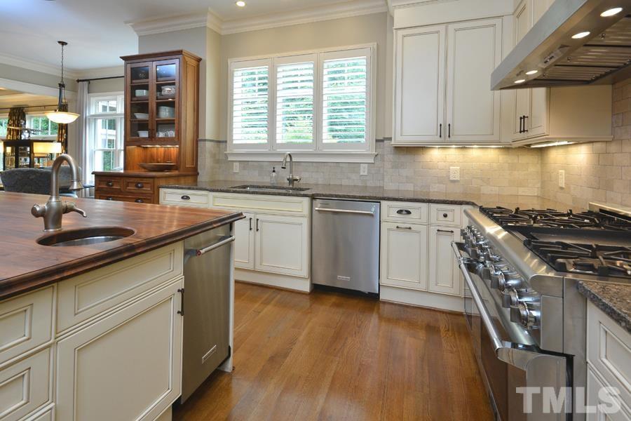 7 Springhouse Place Durham, NC 27705 - Photo 10 of 30 a kitchen with stainless steel appliances granite countertop a sink stove and cabinets