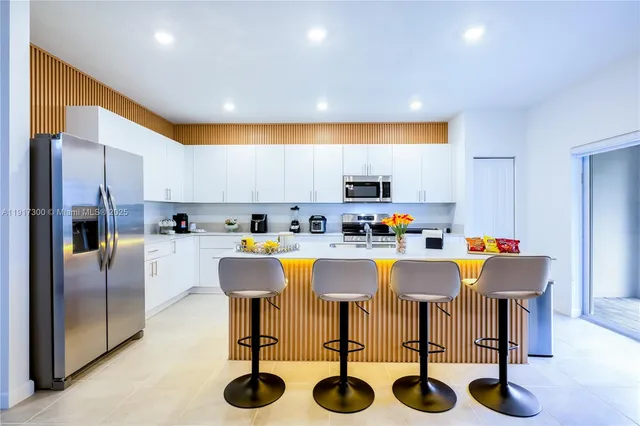 a kitchen with a table chairs and a refrigerator
