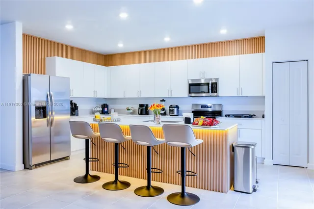 a view of kitchen with refrigerator and microwave