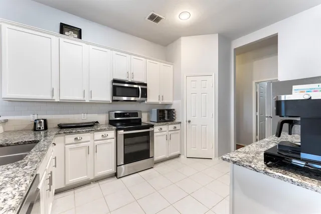 a kitchen with cabinets stainless steel appliances and a sink