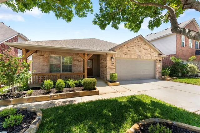 a front view of a house with a yard and potted plants