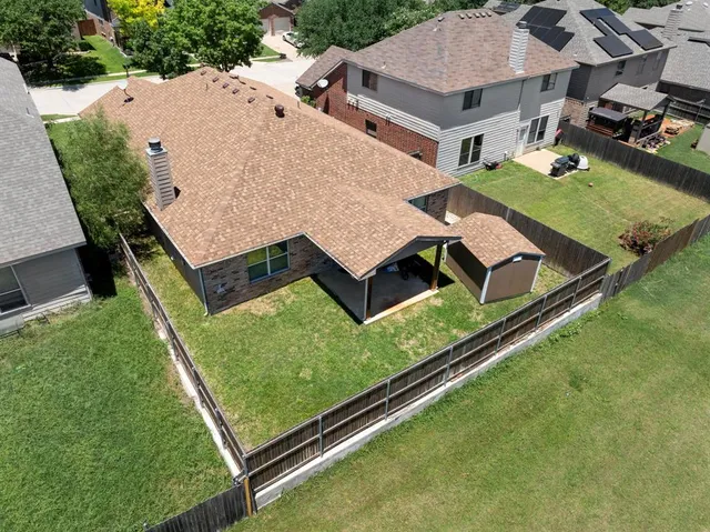 an aerial view of residential house with outdoor space and trees