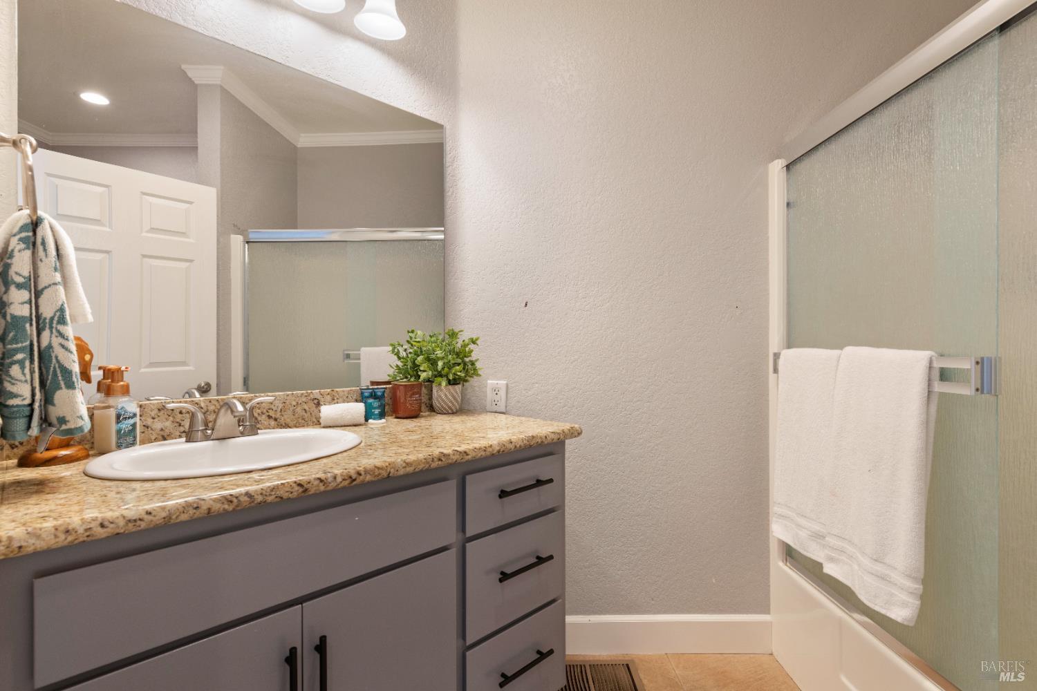 11115 Lakeshore Drive Clearlake, CA 95422 - Photo 30 of 69 a bathroom with a granite countertop sink and a mirror