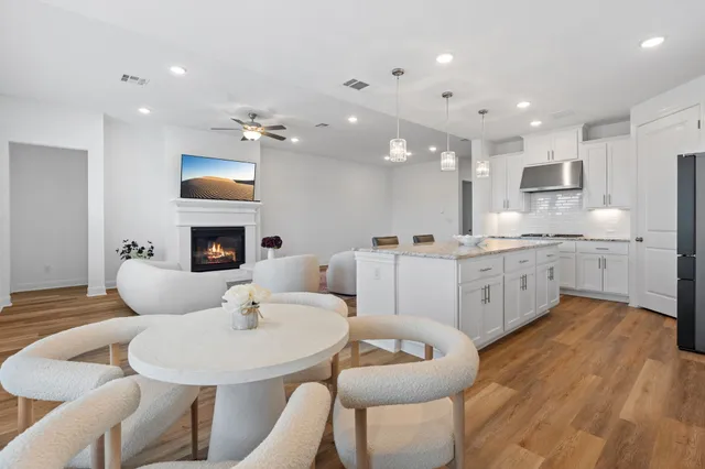 a living room with furniture a fireplace and a open kitchen view