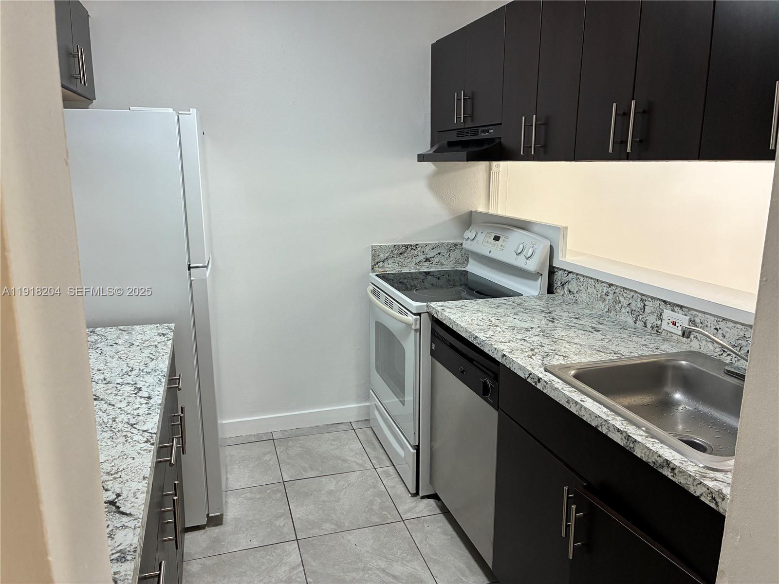 10801 Southwest 109th Court, Unit D203 Miami, FL 33176 - Photo 1 of 28 a kitchen with a sink and a stove top oven