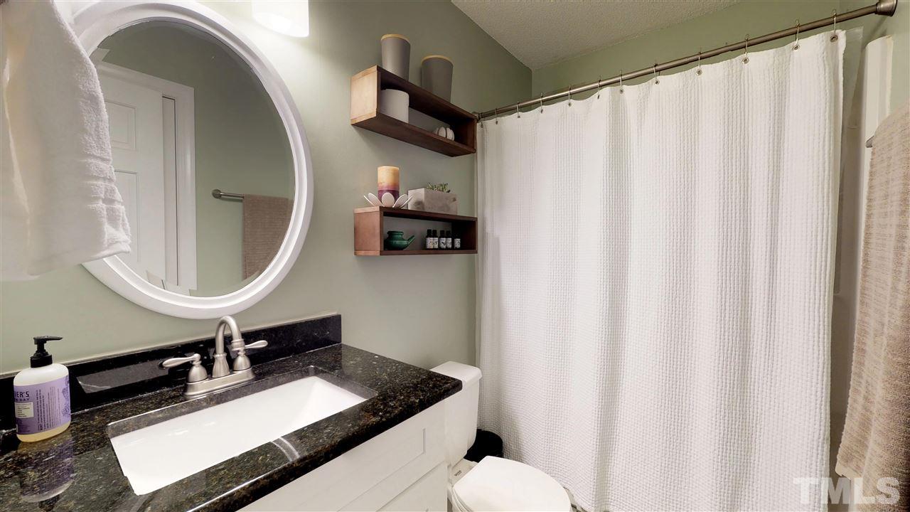 3113 East Folkestone Place Raleigh, NC 27604 - Photo 15 of 23 a bathroom with a sink a mirror and a toilet