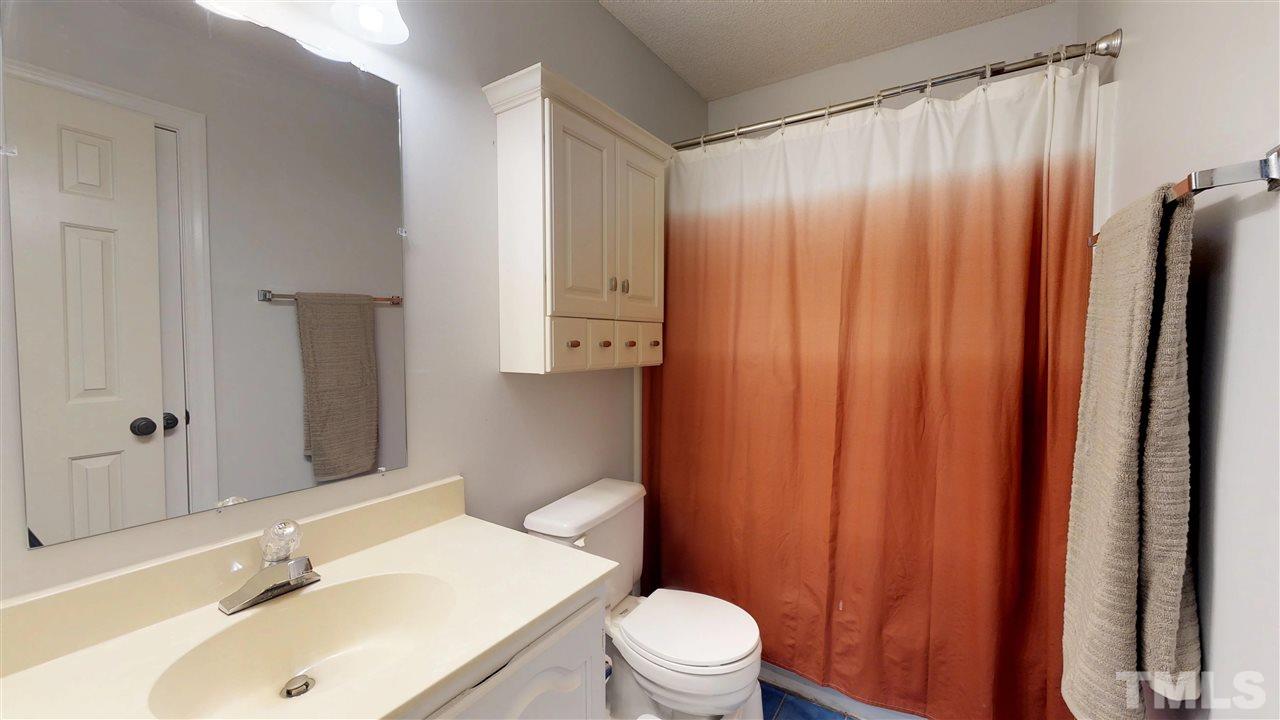 3113 East Folkestone Place Raleigh, NC 27604 - Photo 20 of 23 a bathroom with a sink a toilet and shower curtain