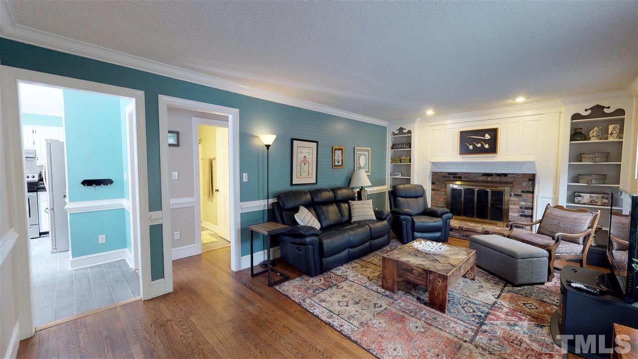 3113 East Folkestone Place Raleigh, NC 27604 - Photo 7 of 23 a living room with furniture flat screen tv and a fireplace