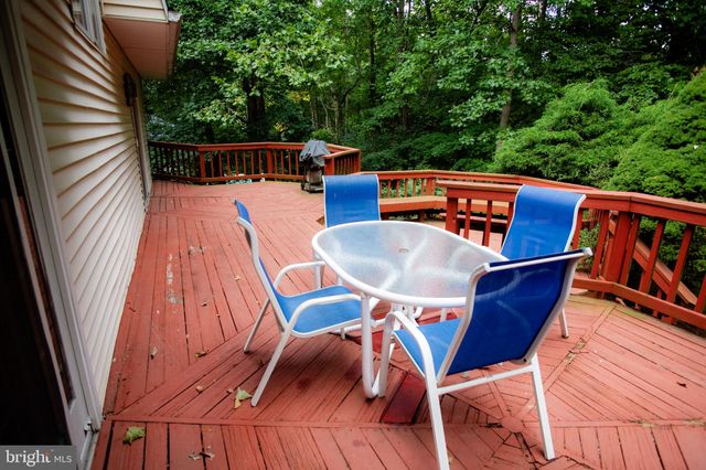 a balcony with wooden floor table and chairs