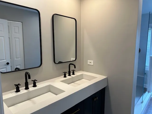 a bathroom with double vanity sinks and a mirror