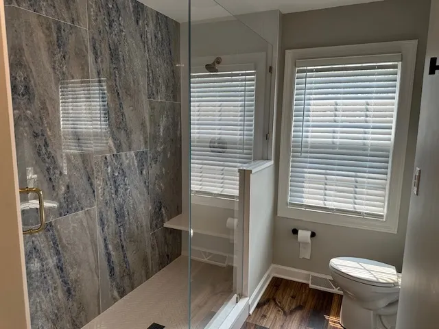 a bathroom with a toilet and a shower