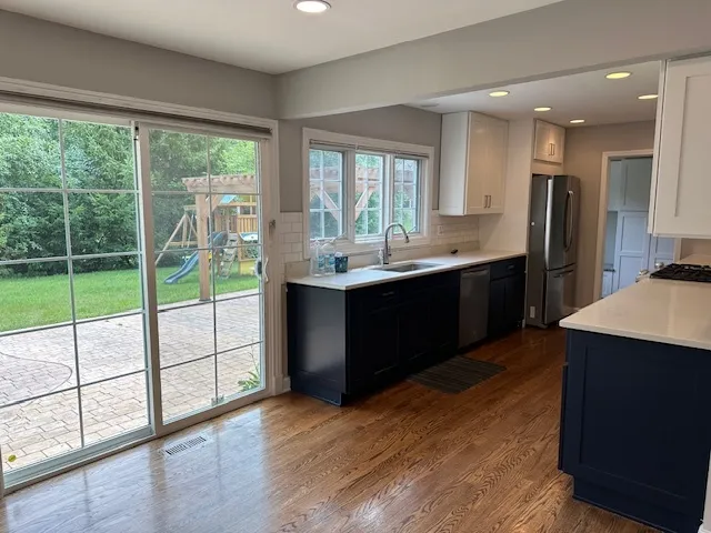 a kitchen with a sink a counter top space and stainless steel appliances