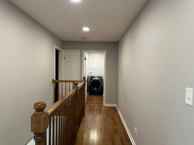 a view of a hallway with wooden floor and stairs