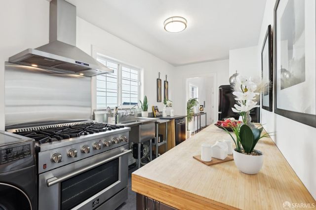 a kitchen with stainless steel appliances kitchen island granite countertop a stove a sink and a refrigerator