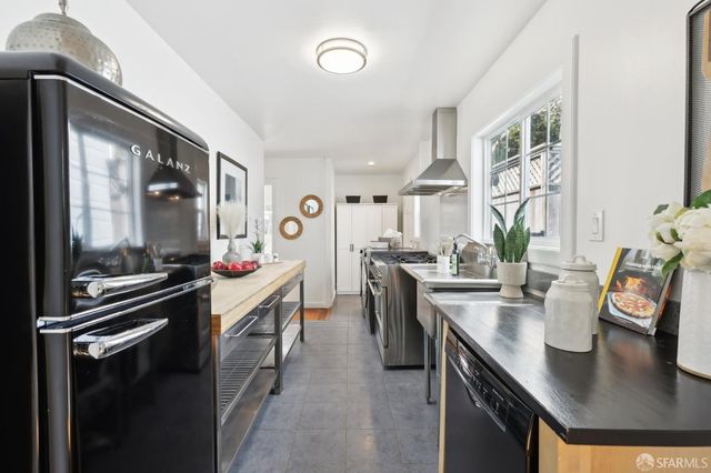 a kitchen with kitchen island a stove a sink and a refrigerator