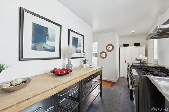 a kitchen with stainless steel appliances a stove a table and chairs