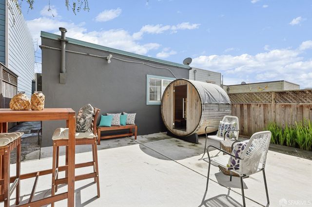 a front view of a house with garden and chairs