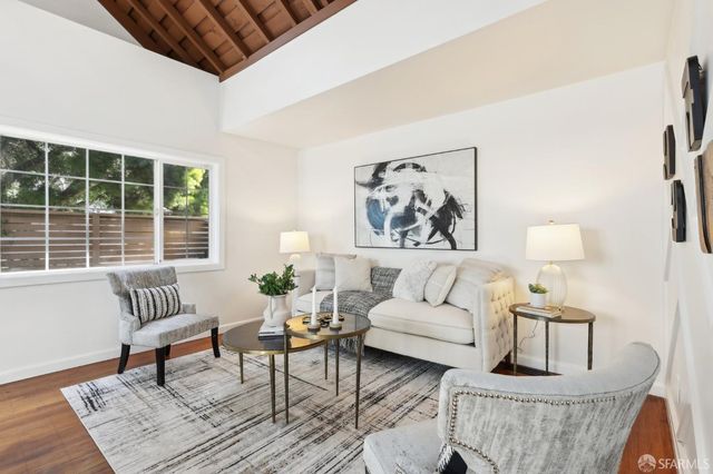 a living room with furniture and a painting on the wall