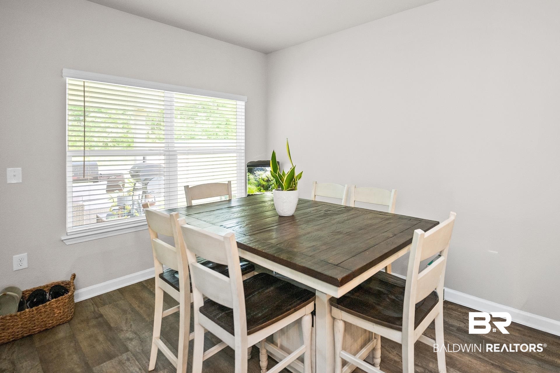 23997 Veranda Circle Elberta, AL 36530 - Photo 8 of 28 Dining area featuring wood-finish flooring, a large window with horizontal blinds, and neutral-toned walls