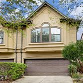 a view of a brick house with a large windows and flower plants