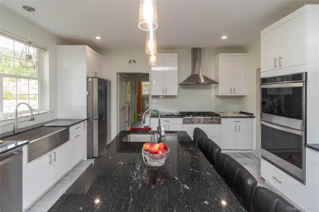 a large kitchen with stainless steel appliances granite countertop a stove a sink and a refrigerator