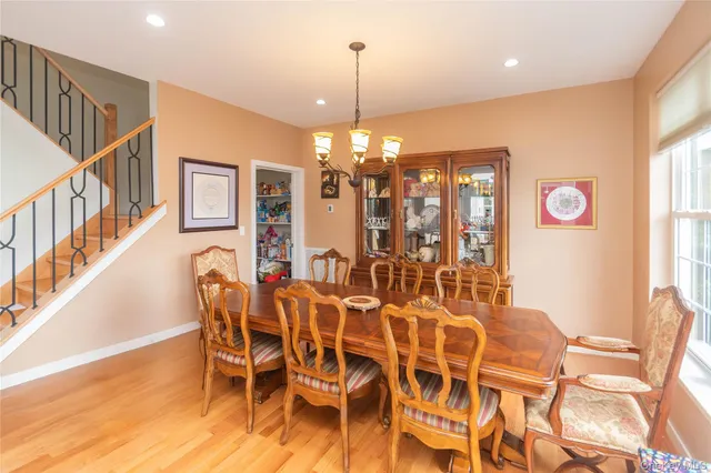 a view of a dining room with furniture a chandelier and large windows