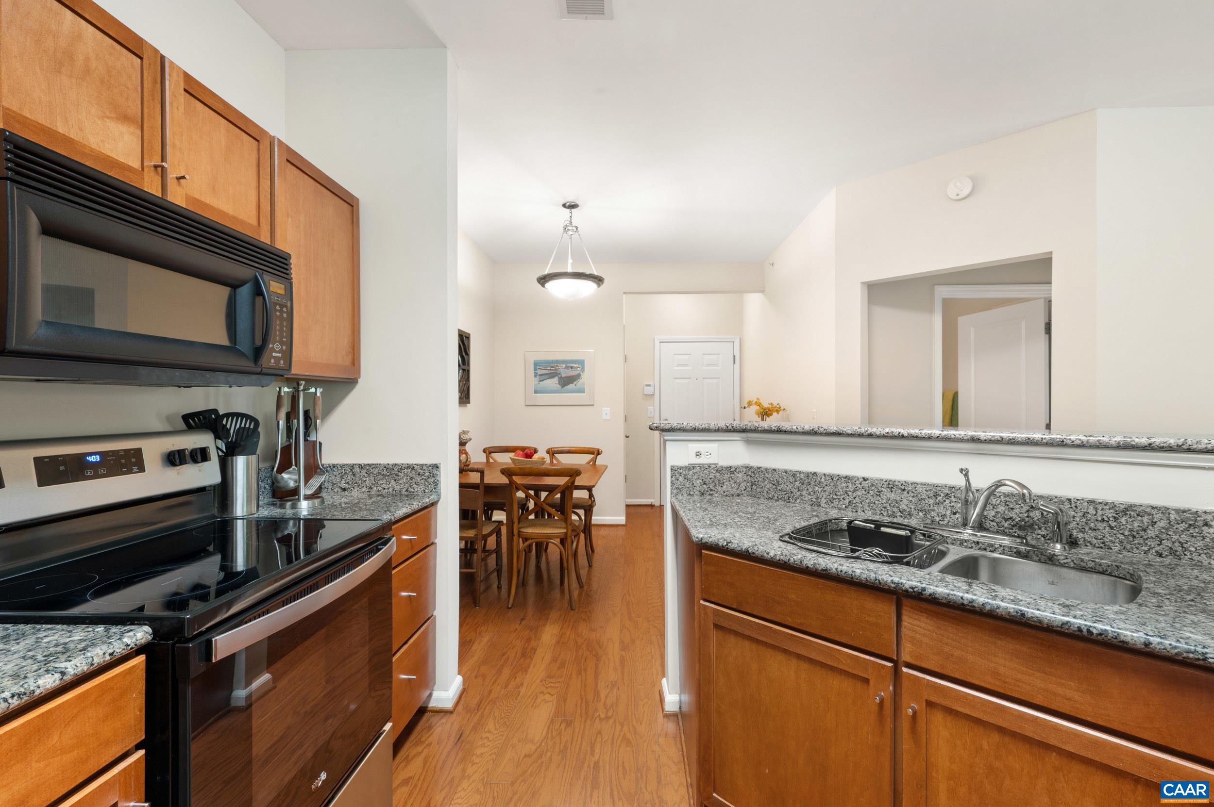 765 Walker Square, Unit 2D Charlottesville, VA 22903 - Photo 10 of 33 a kitchen with stainless steel appliances granite countertop a stove a sink and a microwave