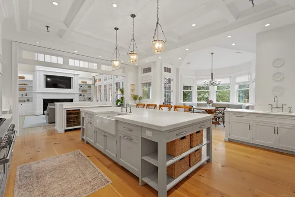 a large kitchen with a large counter top a sink stainless steel appliances and cabinets