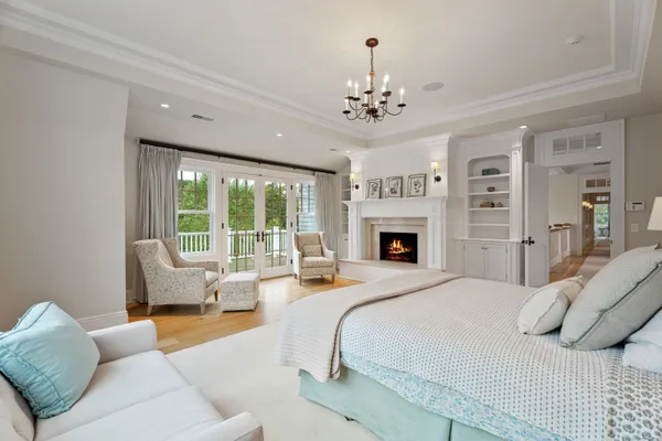 a bedroom with a large bed couch and windows