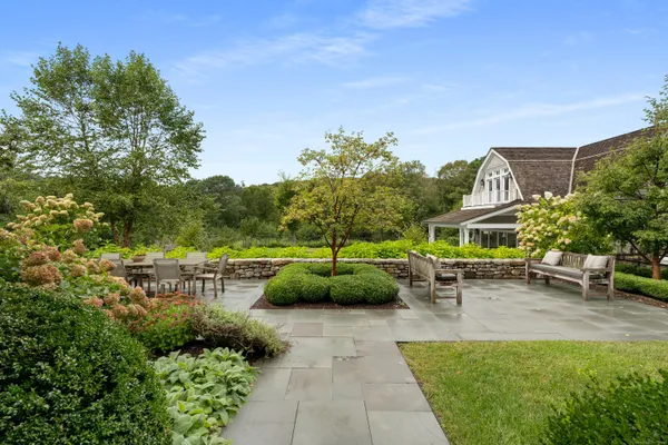 a view of a backyard with table and chairs and potted plants