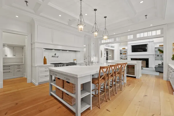 a kitchen that has a lot of cabinets a sink and a wooden floor