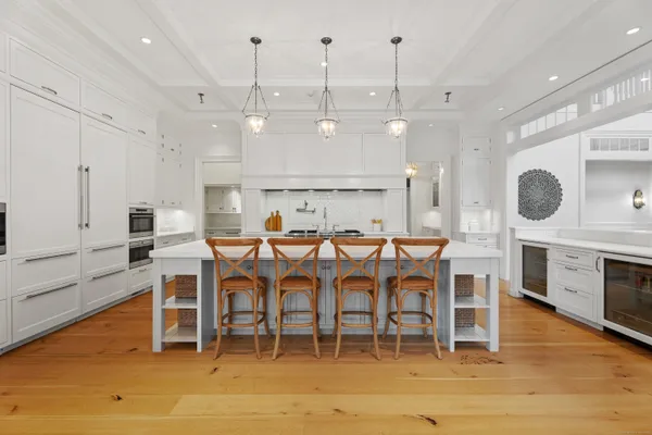 a kitchen with stainless steel appliances kitchen island granite countertop a table chairs and a fireplace