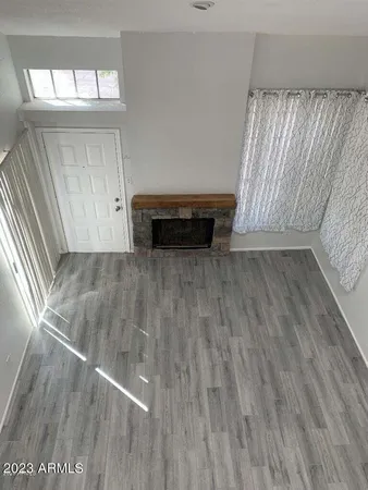 a view of a livingroom with wooden floor and staircase