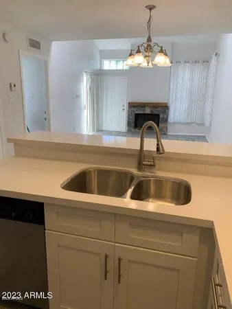 a close view of a sink and dishwasher with kitchen island