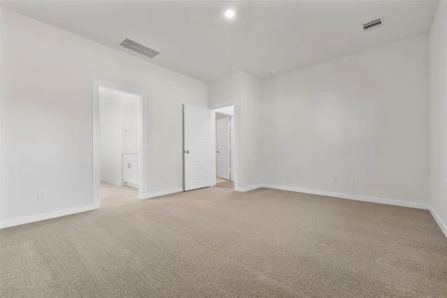a view of an empty room and chandelier fan