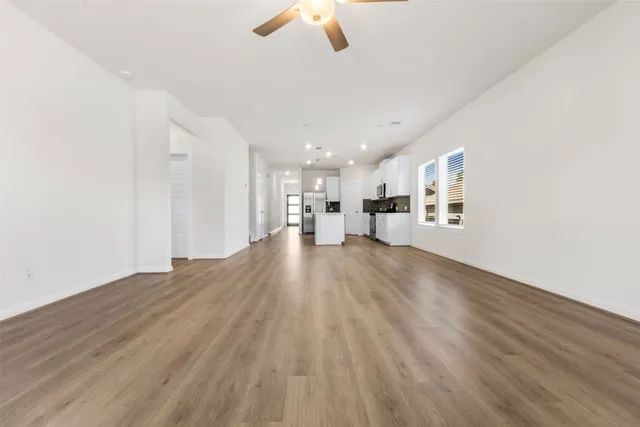 a view of empty room with wooden floor