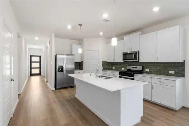 a kitchen with stainless steel appliances a refrigerator stove microwave and cabinets