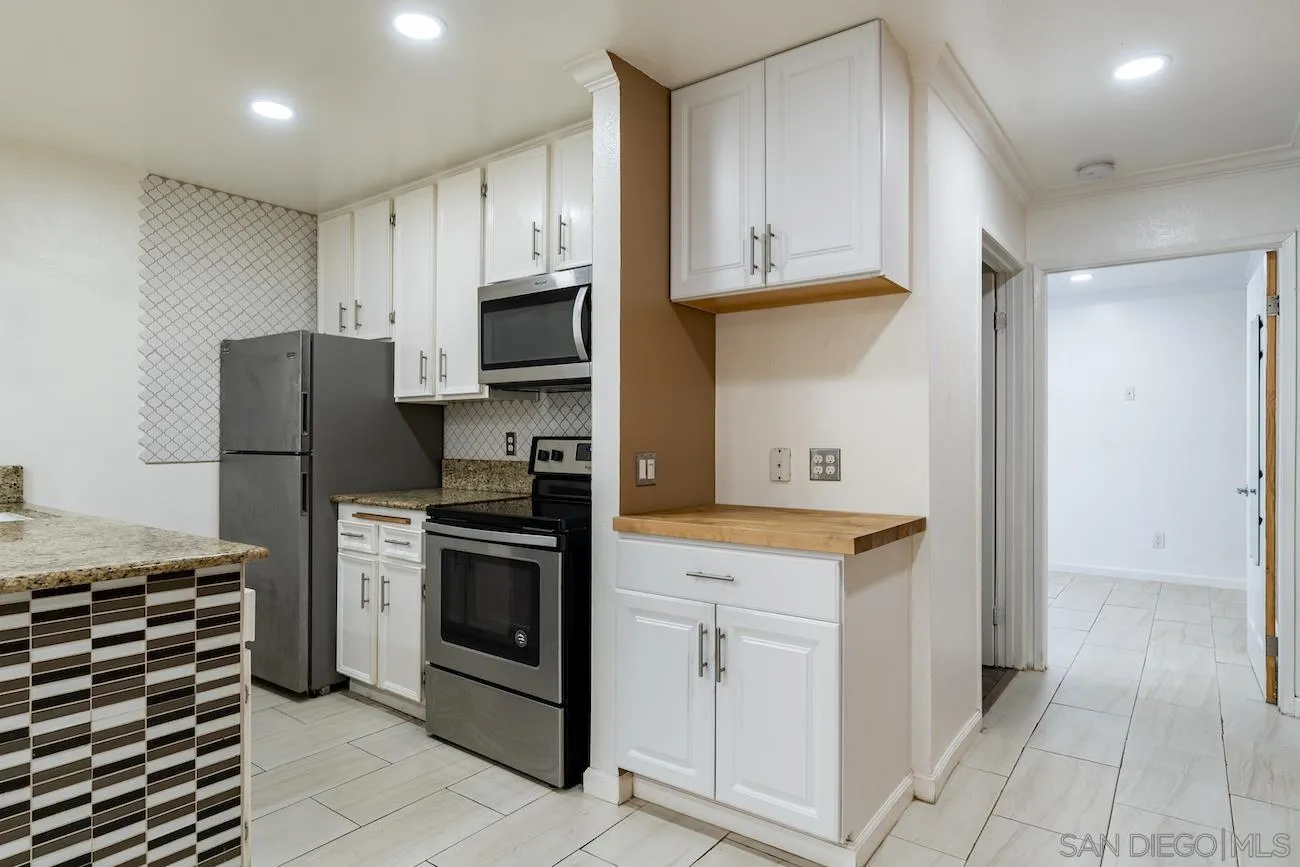 a kitchen with white cabinets and stainless steel appliances