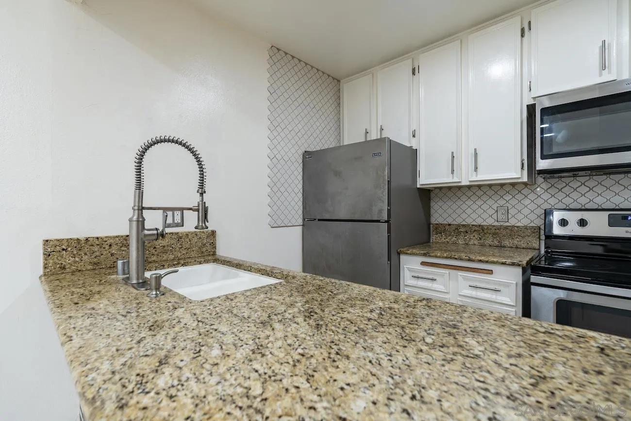 615 Vine Street, Unit 15 Oceanside, CA 92054 - Photo 13 of 23 a kitchen with granite countertop a refrigerator and a stove top oven