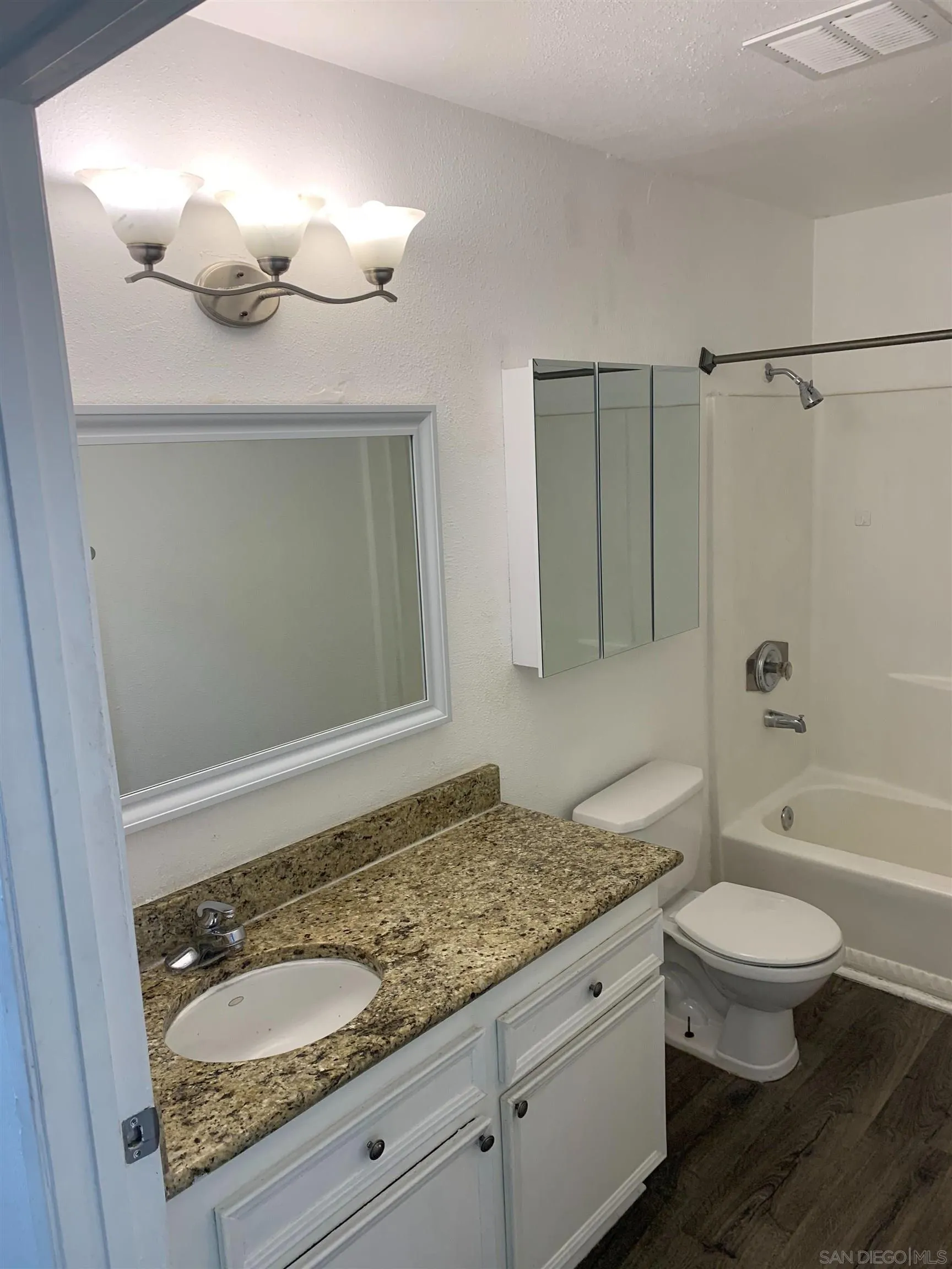 615 Vine Street, Unit 15 Oceanside, CA 92054 - Photo 20 of 23 a bathroom with a granite countertop sink a toilet a mirror and shower