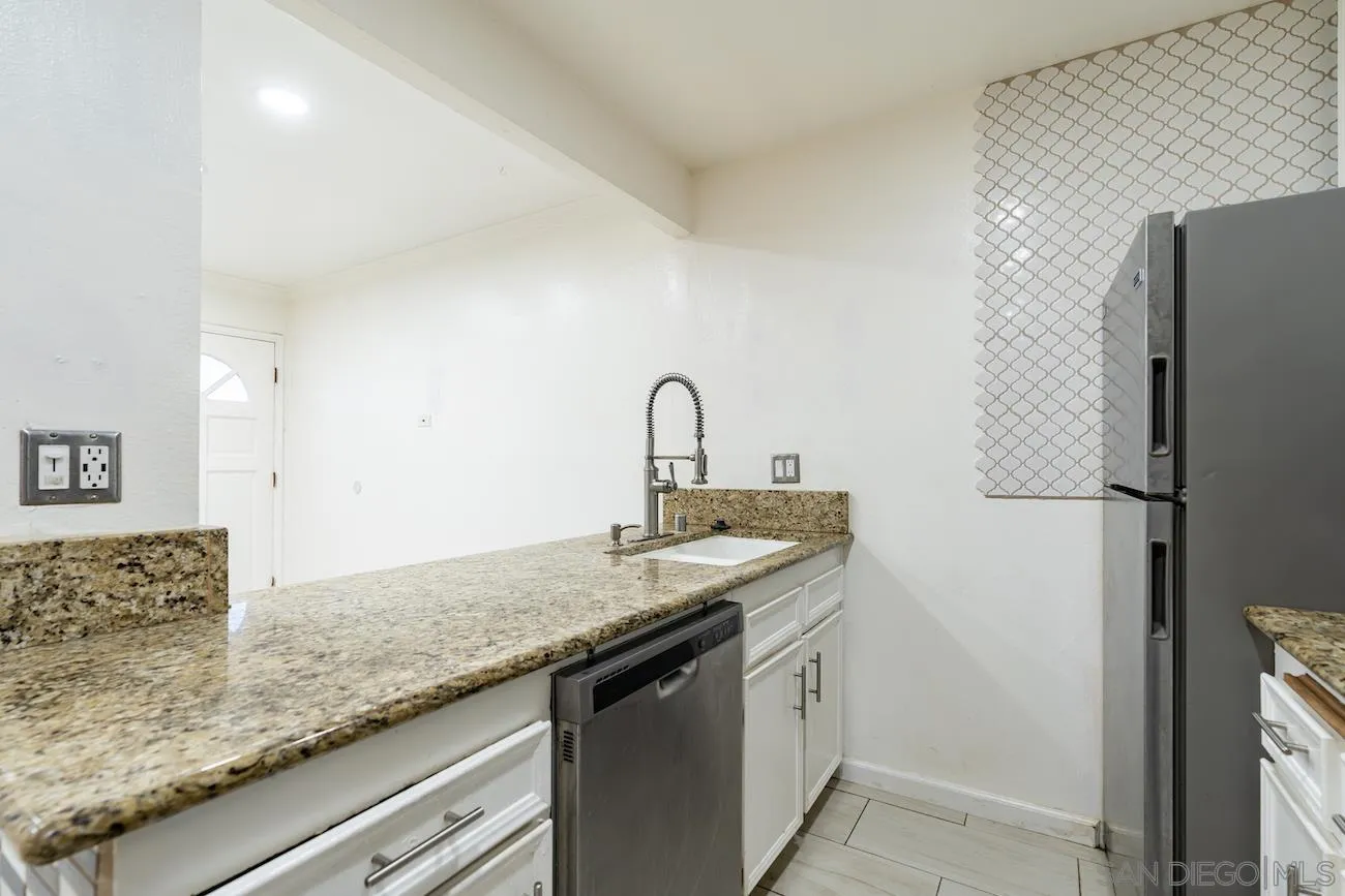 615 Vine Street, Unit 15 Oceanside, CA 92054 - Photo 4 of 23 a kitchen with granite countertop a sink and a refrigerator