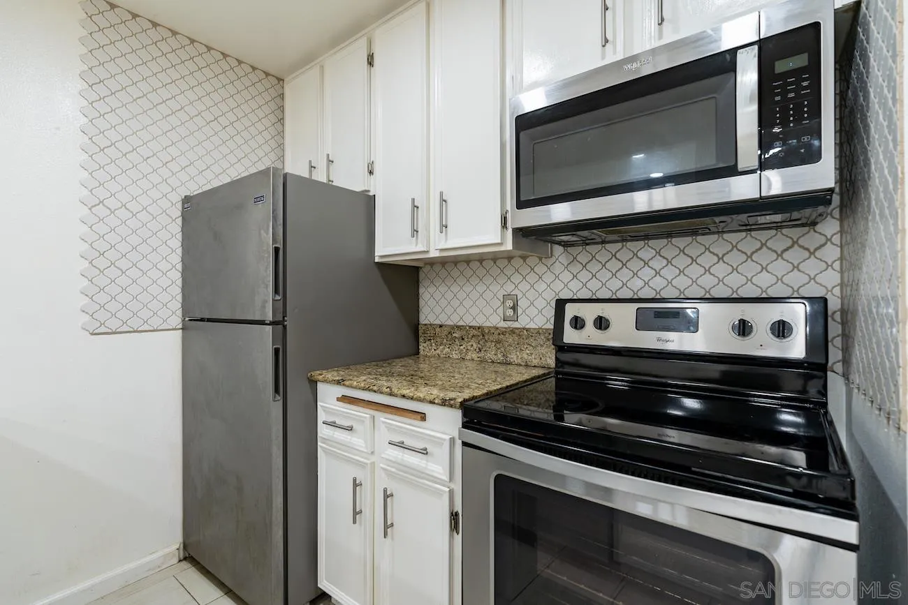 615 Vine Street, Unit 15 Oceanside, CA 92054 - Photo 5 of 23 a kitchen with stainless steel appliances white cabinets and a stove top oven