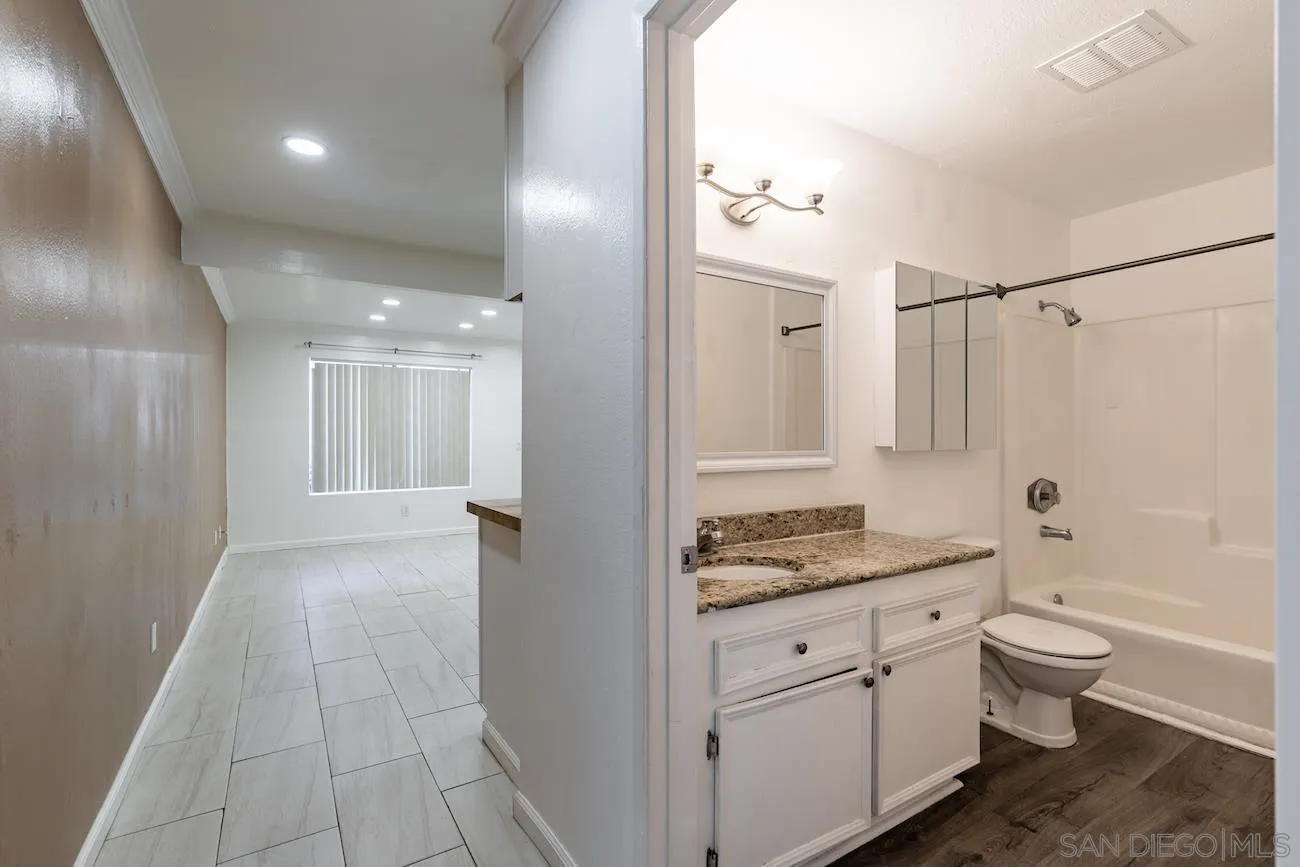615 Vine Street, Unit 15 Oceanside, CA 92054 - Photo 9 of 23 a bathroom with a granite countertop sink a toilet a mirror and shower