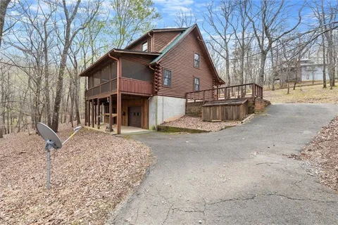 a view of a house with a yard and large trees