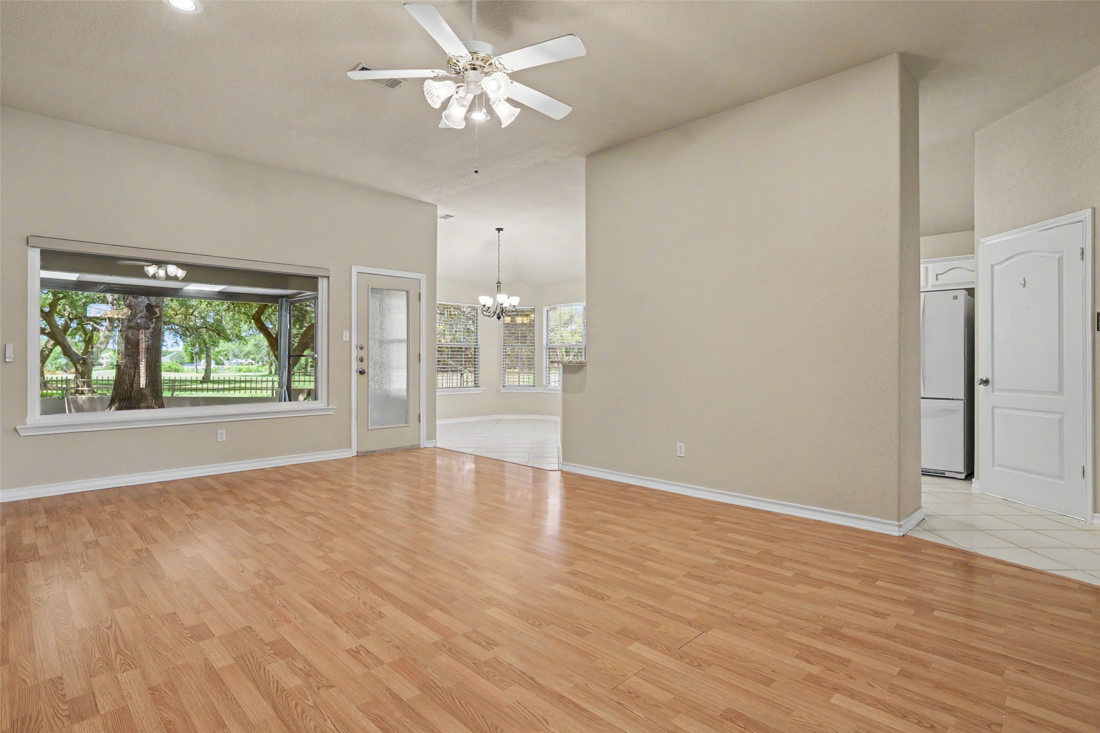 30107 Hamlet Circle Georgetown, TX 78628 - Photo 7 of 40 Laminate flooring extends throughout this generous living space, leading to a vibrant backyard view through wide windows.