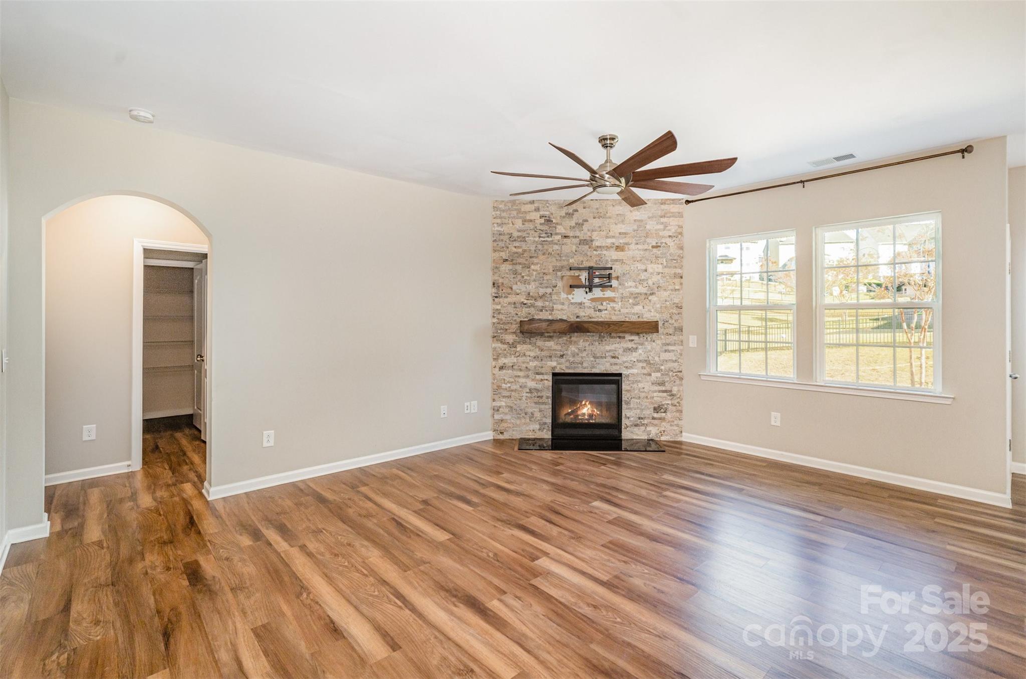 810 Braddock Way Fort Mill, SC 29715 - Photo 14 of 38 an empty room with a fireplace and wooden floor