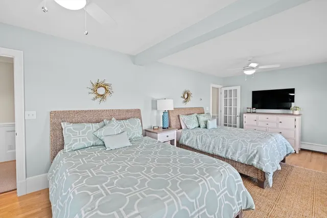 a bedroom with two beds and a flat screen tv