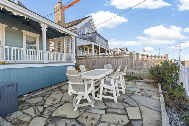 a view of a patio with table and chairs with wooden floor and fence