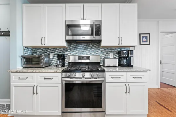 a kitchen with stainless steel appliances granite countertop a refrigerator stove and sink